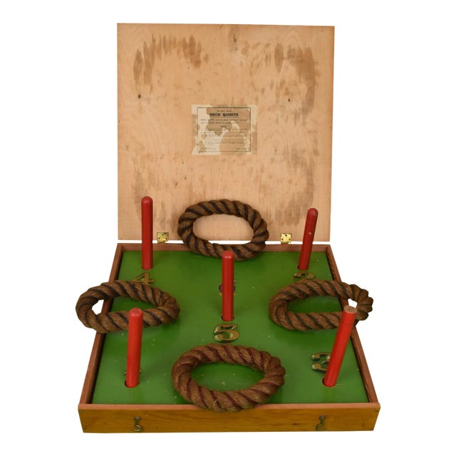 Box Sz: 19"Sq x 2 3/4"D w/ 5 red wooden pegs Sz: 7"L w/ 4 hemp rings Sz: 8"D Classic game of rope quoits or Deck quoits as...