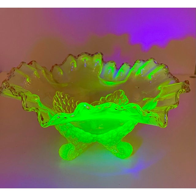 This EAPG vaseline glass footed bowl has a ruffle rim trimmed in a raspberry pink rim. Made circa 1902 by Jefferson /...