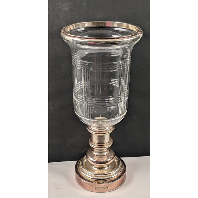Elegant and substantial Ralph Lauren Home hurricane candle holder featuring a polished silver-tone metal pedestal base...