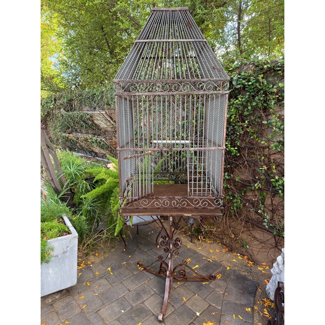 A spectacular, monumental 77-inch tall custom artisan birdcage on a matching scrolled stand. Standing nearly six and a...