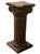 A dark stained wooden pedestal display or plant stand in the form of a classical architectural column with a fluted shaft,...