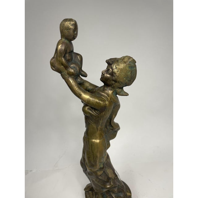 Vintage bronze sculpture depicting a woman lifting a child, 1930s. Beautiful decorative object.