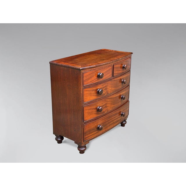 A mid-19th-century mahogany miniature bow-fronted chest of drawers, featuring a moulded mahogany cross-banded top above...