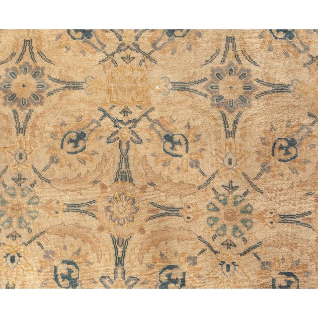 This antique circa-1920 Persian Tabriz rug features an elaborate all-over design of floral motifs and abstractions in what...