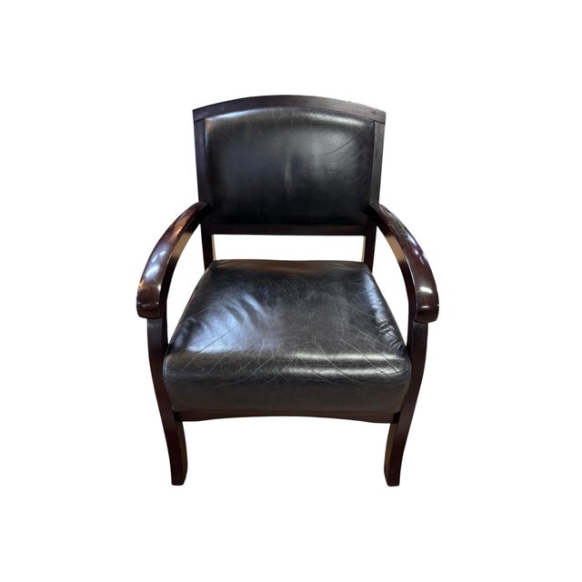 Handsome upholstered armchair combining a rich espresso-brown wood frame with black leather upholstery and bold,...