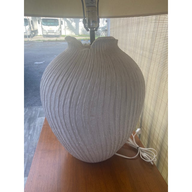 vintage postmodern table lamp,from the 1980s, featuring a textured white plaster base with a swirling or ribbed pattern....
