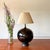 Elegant globe shaped lamp with walnut accents. Body of the lamp is ceramic with black shiny glaze. Very large, making this...