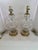 A matching pair of neoclassical urn-form table lamps with diamond-pattern glass bodies, fluted necks, and faceted pedestal...