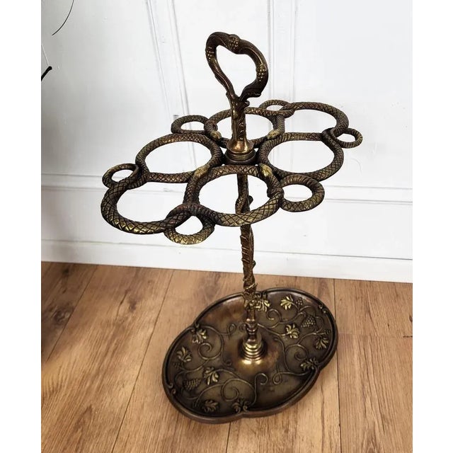 Beautiful and elegant golden cast iron umbrella stand. The top is decorated with four snakes and their heads, the central...