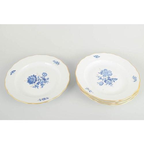 Meissen 4 dinner plates, early 20th century. Hand-decorated porcelain with hand-painted blue floral motifs and gilt...