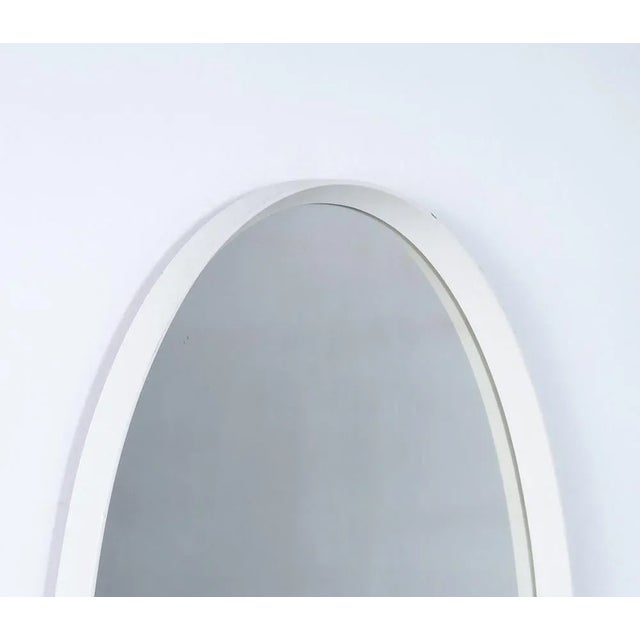 Vintage oval shaped mirror with white wooden frame.