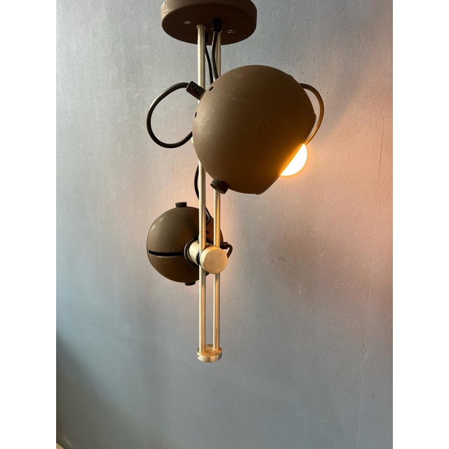 Mid-century ceiling lamp featuring two brown eyeball spotlights with a sleek and versatile design. The metal spots can...
