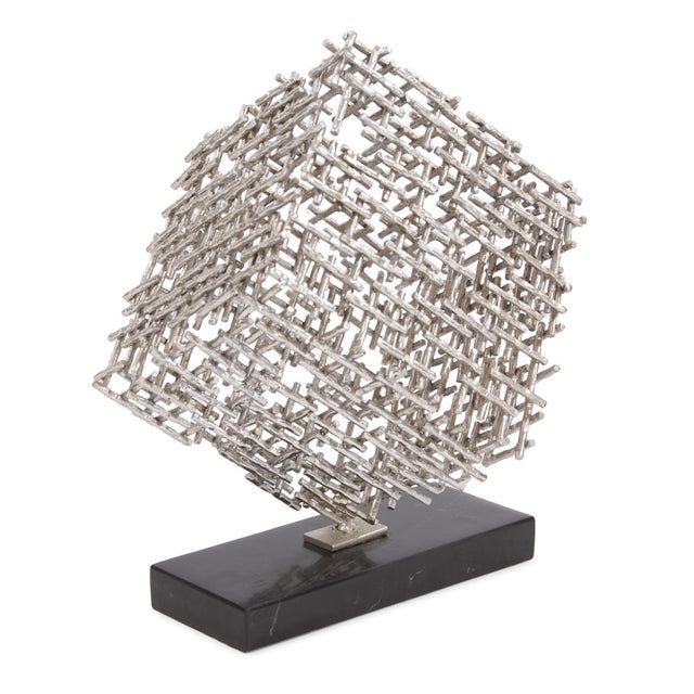 Our Cubist Statue features a cube is a network of small silver metal rods fashioned into a cube shape turned up on its...