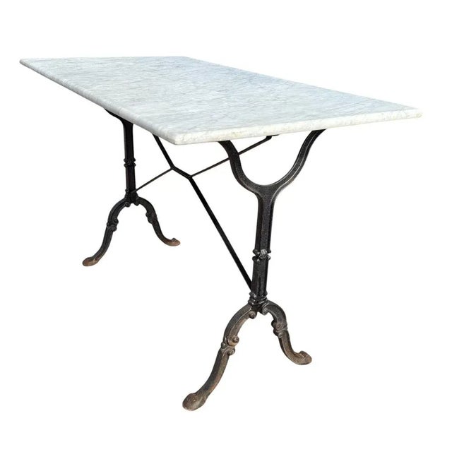 1960s bistro table. X-shaped legs in cast iron and wrought iron with original white marble top. from a Parisian brasserie