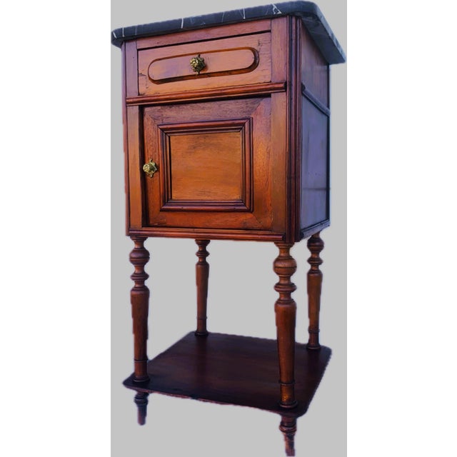 Narrow cabinet with black marble top, 19th century made of oak and walnut wood and a black marble top with white threads...