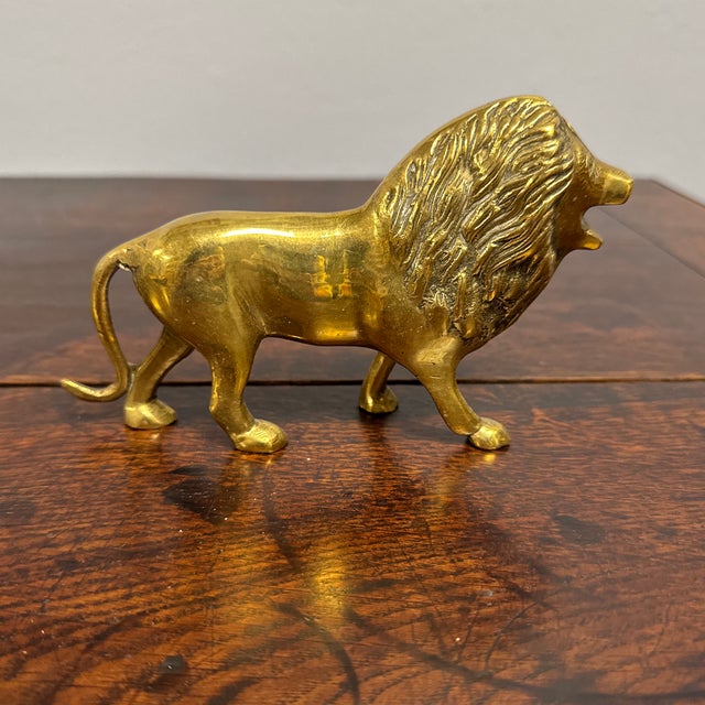 This vintage brass lion figure showcases impressive craftsmanship with intricate detailing, particularly in the flowing...