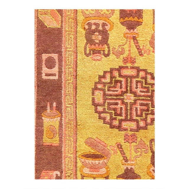 A antique Chinese oriental rug, s circa 1920. This lovely small decorative carpet features a GOLD central field with a...