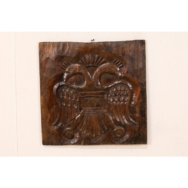 A Guatemalan wood carved decorative wall hanging plaque. This Guatemalan wood plaque, from the early 20th century features...