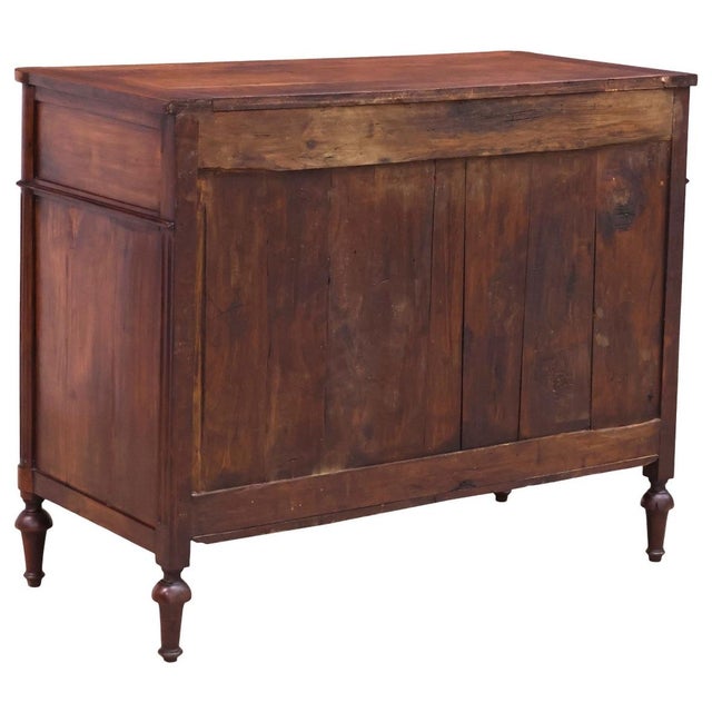 French Louis XVI style walnut commode, 19th c. Shaped top, over three drawers flanked by fluted corner posts, on tapering...