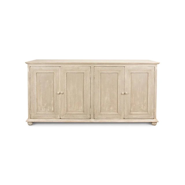 Made of pine with an antiqued and distressed hand-painted finish in a coastal beach beige color. With four doors framed in...
