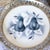 A beautiful set of silver plates with one being a handpainted pear plate. The pair plate is on blue and white ceramic from...
