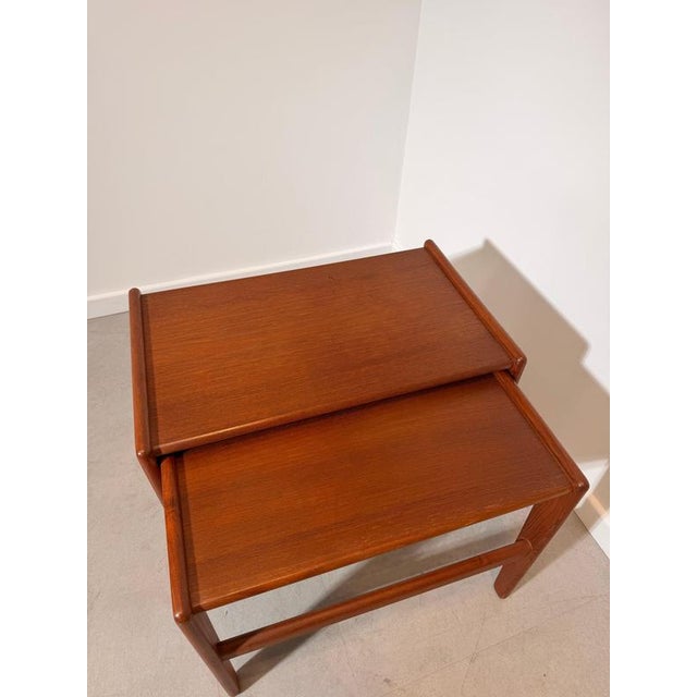 Beautiful set of two vintage Danish modern nesting tables crafted from warm teak wood. These elegant side tables feature...