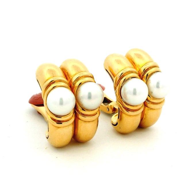 A striking pair of vintage Bvlgari 18K yellow gold earrings featuring luminous cultured pearls in a sculptural Italian...