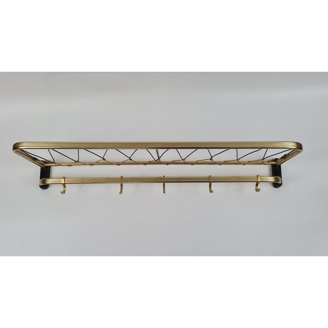 This wall hanger with a shelf, made in Germany in the 1970s, is an example of mid-century modern design with a clear...