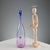 Slightly ribbed, spiral-shaped pink glass bottle with a blue cap. Signature of the designer and manufacturer's sticker....