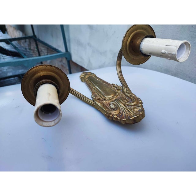 Art deco, brass double wall lamp, dimensions: height 27 cm, width 24 cm, depth 9 cm. Installation and frames replaced....