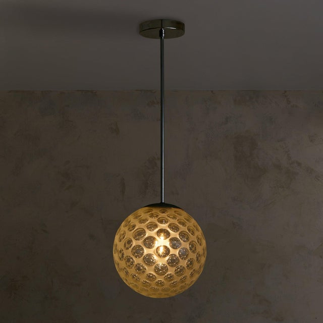 An Italian Murano glass pendant light, attributed to Carlo Scarpa and dating to 1935. The spherical globe is formed from...
