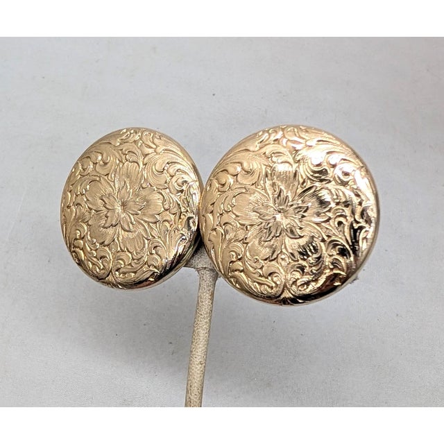 Round goldtone etched floral design clip earrings. Marked "NAPIER PAT. PEND." on the clips. Measure: 1 1/2 inches across....