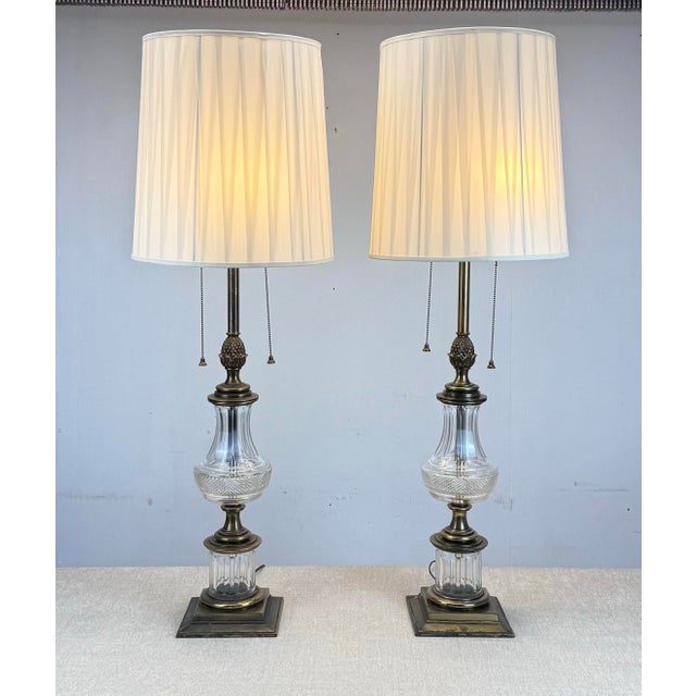 A very tall and impressive pair of Hollywood Regency end table lamps by Stiffel circa 1970’s featuring antique brass...