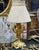 This delicate French-style table lamp combines an elegant gold leaf and bronze-finished base with a softly sculpted...