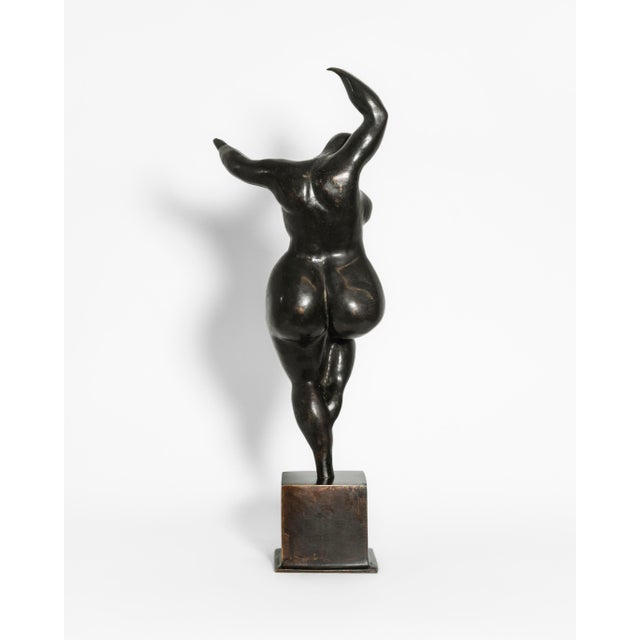 A contemporary figurative bronze of a woman caught mid-turn, risen onto the toes of one foot with the other knee lifted...