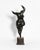 A contemporary figurative bronze of a woman caught mid-turn, risen onto the toes of one foot with the other knee lifted...
