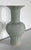 Celadon vase with ventrue belly. The relief sets represent flowers, dotted with leaves, whose long stems form large...