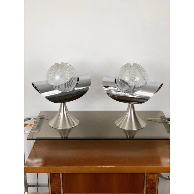 Pair of two table lamps in chrome and glass with a steel base. Typical vintage lamp of the 1970s Italian period. Up to...