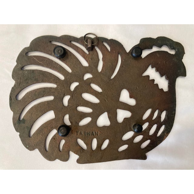 This vintage rooster trivet showcases bold folk art design with pierced detailing that creates depth and visual interest...