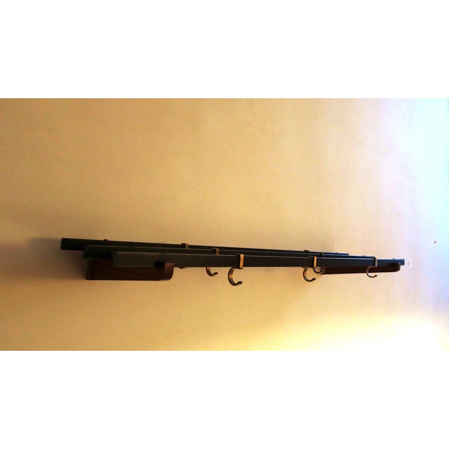 Teak, brass and metal wall mounted coat and hat rack dating from the 1960s, with 7 adjustable sliding hooks.