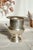 Antique silver-plated champagne bucket, mounted on a wide, elegant base with two delicately designed side handles. The...