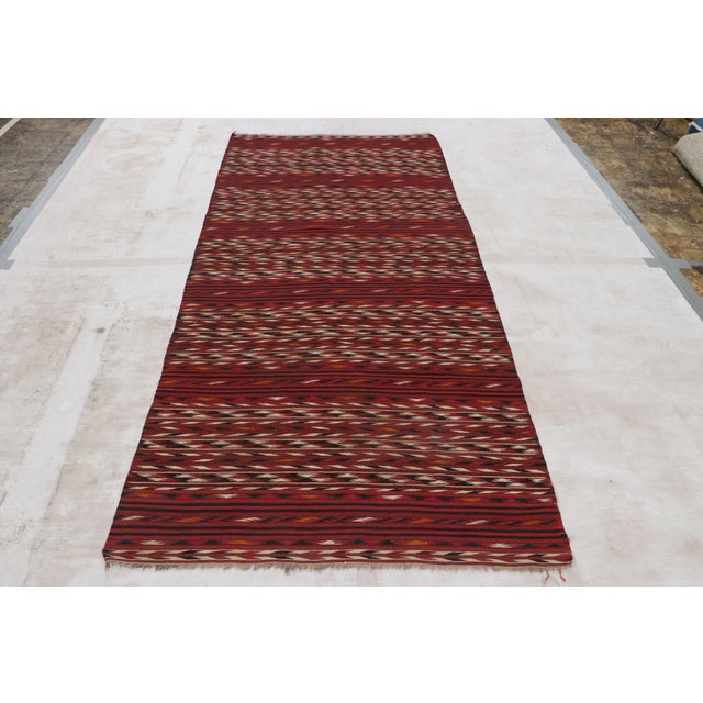 This antique 4x9 Persian kilim runner is a classic tribal rug, handwoven in wool circa 1920-1930. On the Design: The...