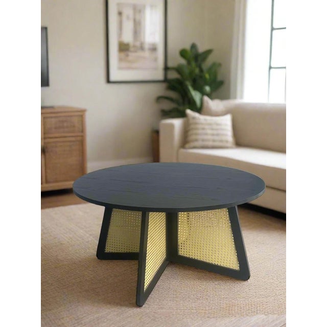 Add a touch of natural charm to your living space with our Shia Cane Round Black Coffee Table. This unique table features...
