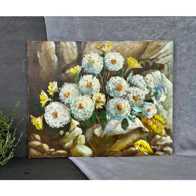 Artfully executed in oil paint on stretched canvas, this vintage floral still life painting has textured white and yellow...