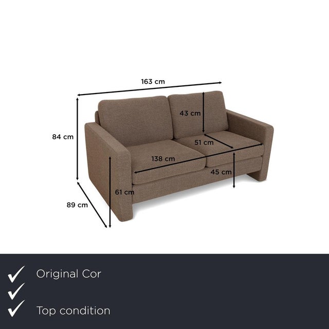 The Conseta two-seater from Cor is upholstered in brown fabric and stands on discreet legs. It is characterized by its...