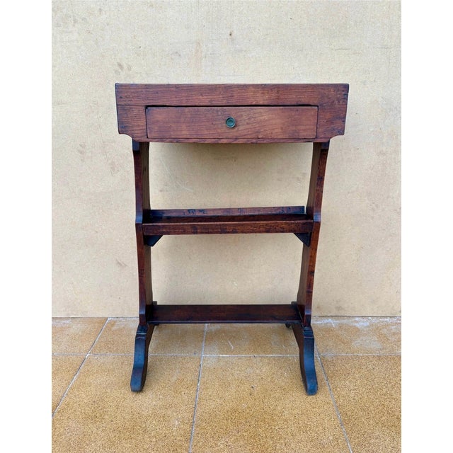 This Spanish rustic side table dates from the 20th century and is crafted in solid chestnut wood. The piece features a...