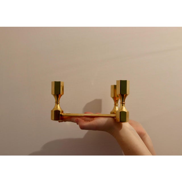 Made in Sweden. This exquisite three-arm candelabra, crafted from solid brass, is a design masterpiece by Lars Bergsten...