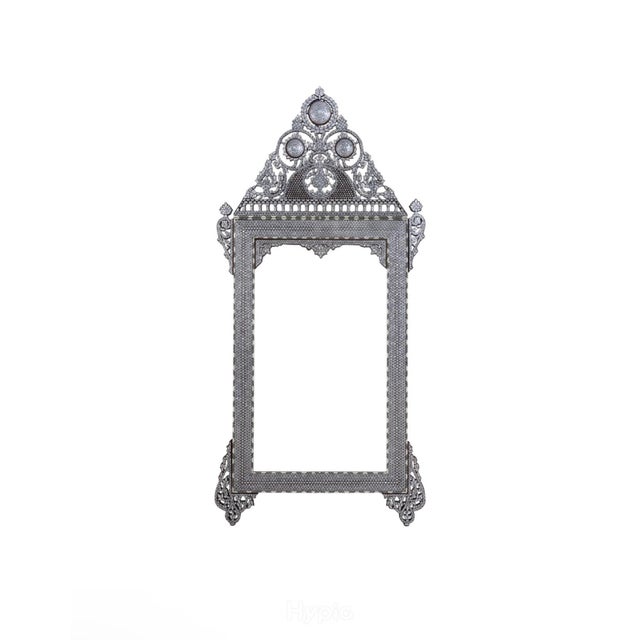 A tall and imposing Damascus wall mirror, the deep walnut frame profusely inlaid with tessellated mother-of-pearl, sea...