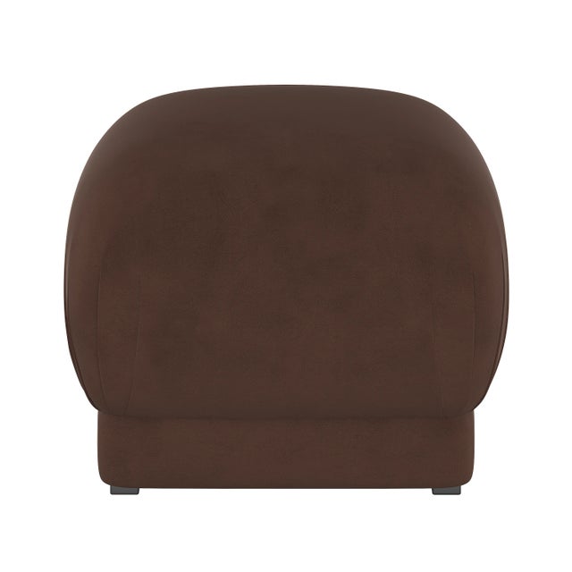 Smooth upholstery covers a sleek cushioned silhouette, accentuated at the corners with delicate handcrafted pleating. The...