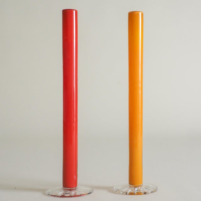 Set of two tall vases by Anne Nilsson for Orrefors, made in Sweden in the 1980s. One in yellow and one in red, each mouth-...